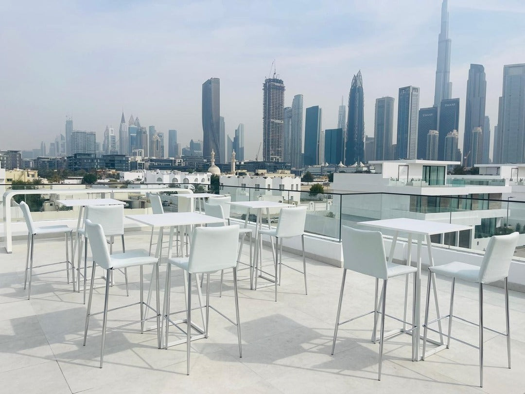 Modern rooftop event venue in Dubai with high tables and skyline views, ideal for customised event setups.