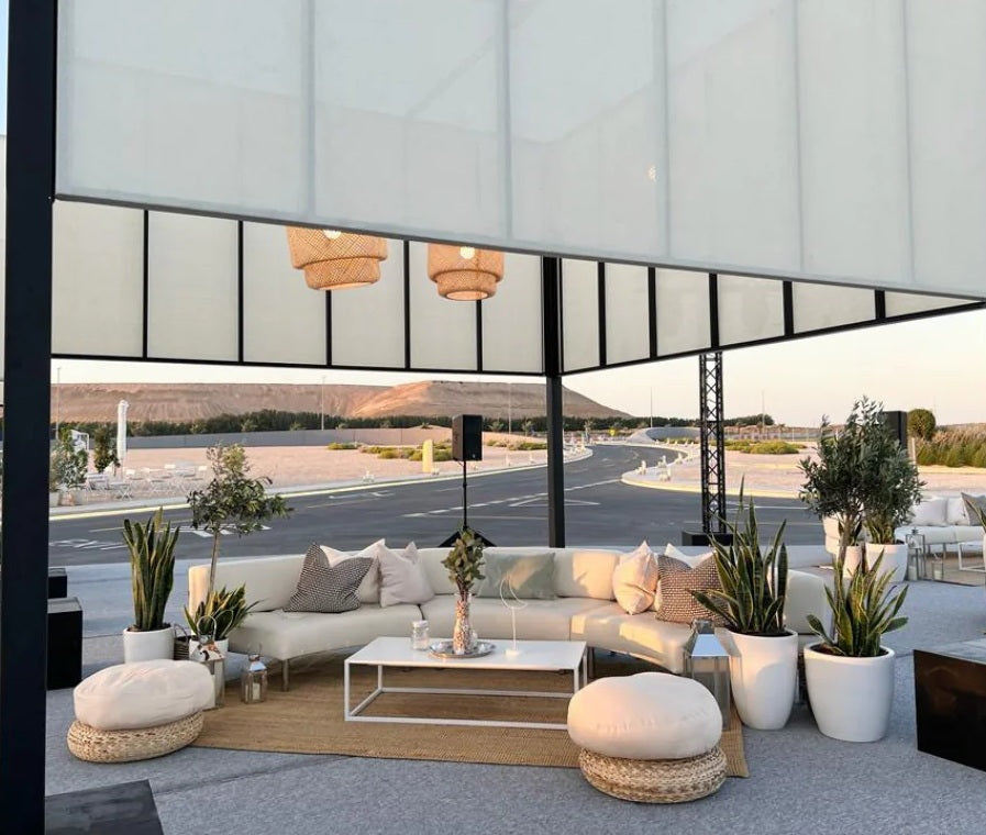 Lounge seating setup under a canopy with plants and warm lighting – perfect for outdoor party theme ideas.